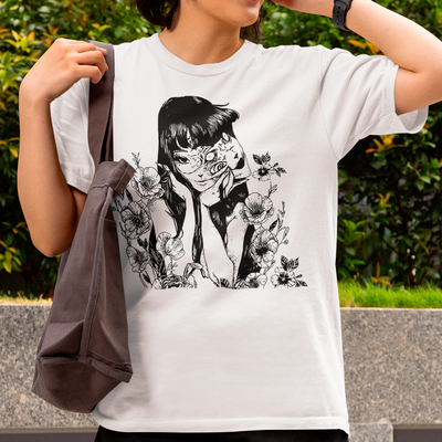 Mulher usando camiseta básica branca  com estampa de junji ito flowers com flores ao lado